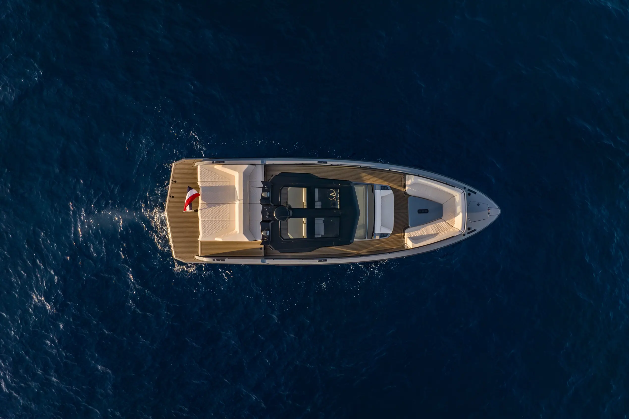 Overhead drone shot of Vanquish VQ40 anchored in turquoise Sardinian water