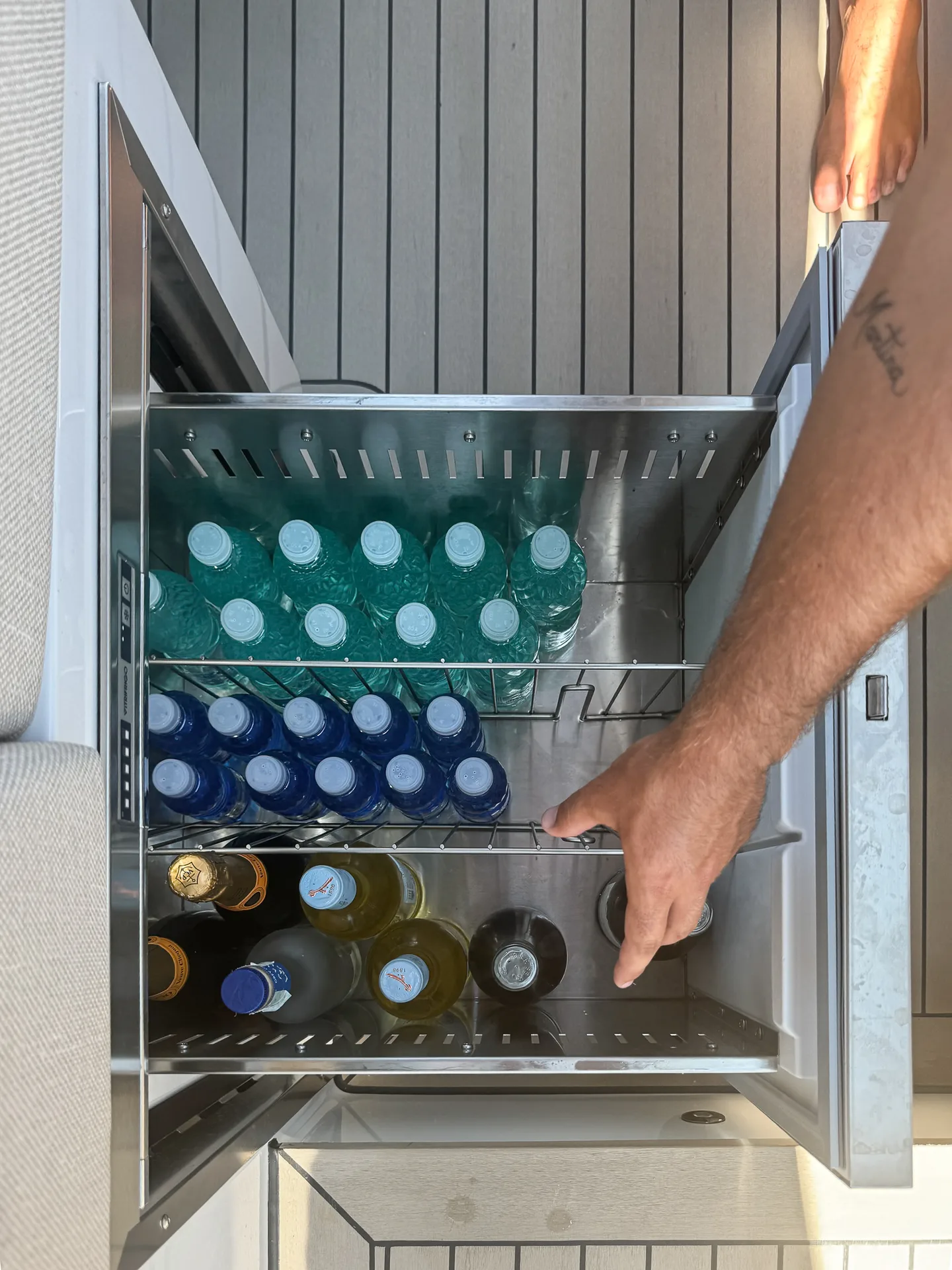 Tappo di champagne che salta con il mare smeraldo dietro