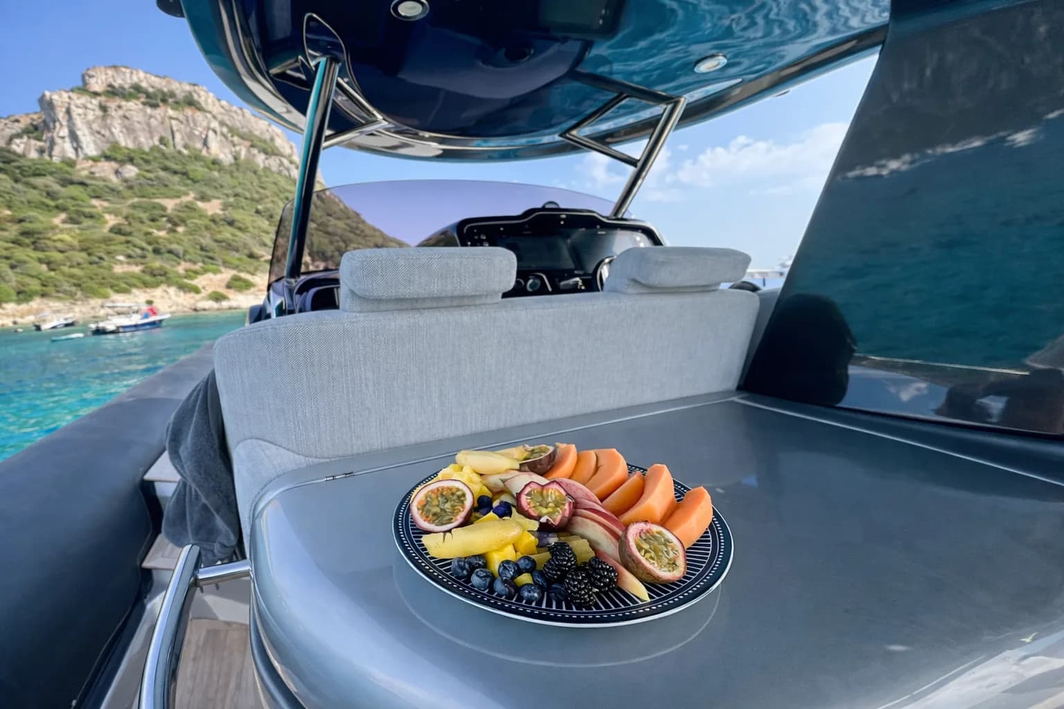 Ospiti che brindano con prosecco all'ancora in una cala turchese