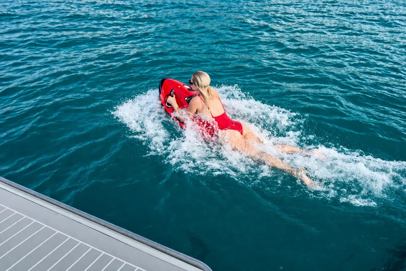 Frau fährt einen roten Seabob unter Wasser im klaren Mittelmeer